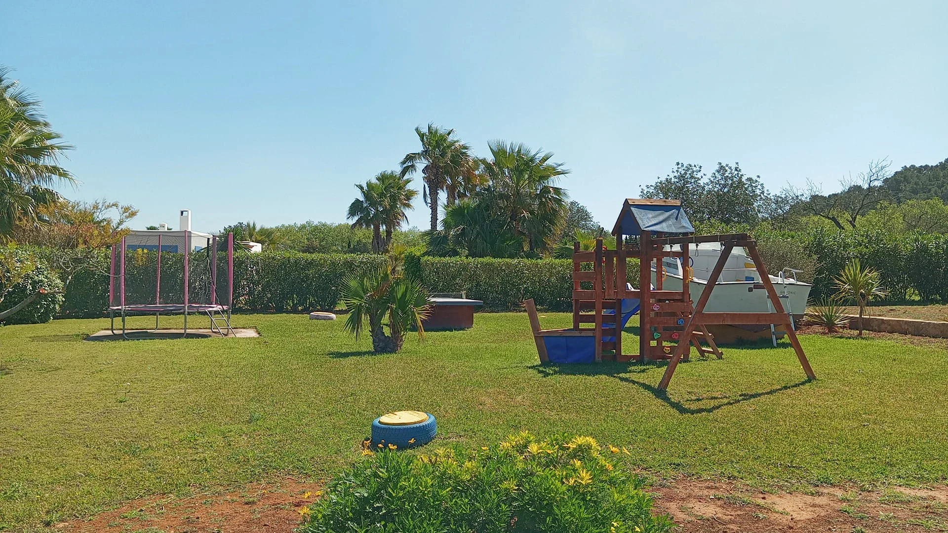 Jardín familiar con columpios y zona infantil